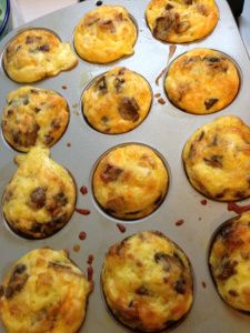 a muffin tin filled with lots of different types of breakfast foods on top of a table