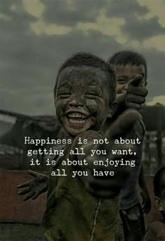 two boys with their faces covered in mud and the words happiness is not about getting all you want, it is about enjoying all you have