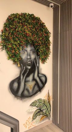 a painting of a woman's head with flowers in her hair on the wall