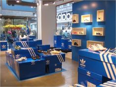 the adidas store is blue and has white stripes on its front, while other shoes are in their boxes