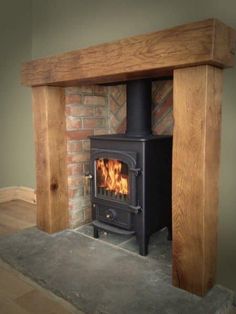 a wood burning stove sitting inside of a living room next to a fireplace mantel