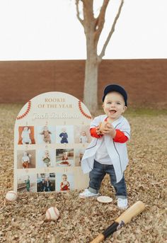 a little boy standing in front of a sign with baseballs and bats on it