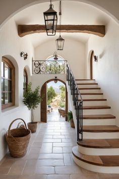 an entry way with stairs and potted plants on either side, leading to the second floor