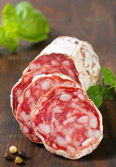 sliced salami meat with basil leaves on the side - stock photo - images, food and drink