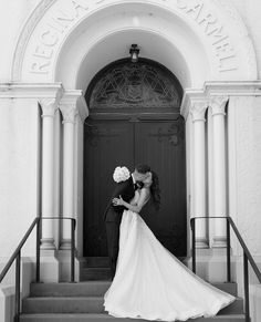 a bride and groom kissing in front of the entrance to their wedding ceremony at st mary's church