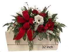 a bouquet of red and white flowers with greenery in a gift bag for someone's birthday