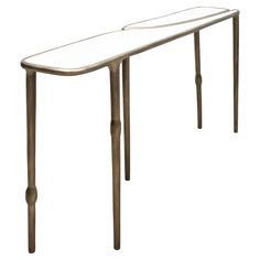 a white table with metal legs and a curved design on the top, against a white background