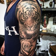 a man with a tiger and rose tattoo on his arm