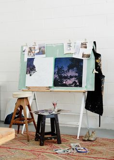 an easel with pictures on it in front of a wall