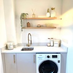 a washer and dryer sitting in a kitchen next to a counter top with shelves above it