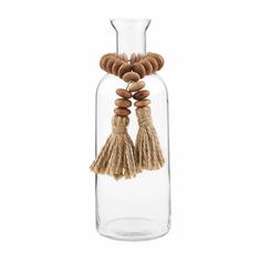 a glass vase filled with wooden beads and tassels