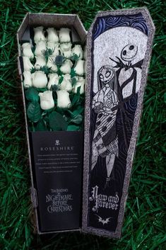 an open box filled with marshmallows on top of green grass next to a fake skeleton