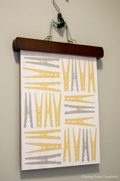 a white and yellow painting hanging on a wall next to a clipboard with scissors