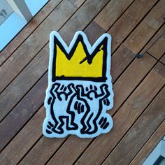 a sticker that has been placed on a wooden floor with the word king written in black and yellow