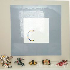 legos are arranged on a shelf in front of a wall with an image made out of lego blocks