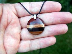 This domed circle necklace features a gorgeous combination of premium woods! Crafted from a hand-selected, artistic composition of domestic and exotic wood species. Carved into a an attractive modern dome shape. A hand rub finish is applied and then the pendant is buffed to a buttery smooth final finish that feels amazing to the touch. You can choose from a variety of necklace/cording options including: 18" or 22" stainless steel chain A variety of colors of satin cording with sliding knots that Artistic Composition, Wood Minimalist, Natural Necklace, Minimalist Pendant, Necklace Wood, Modern Necklace, Wood Disc, Curved Wood, Nature Necklace