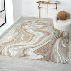 a white chair sitting on top of a wooden floor next to a rug covered in marble