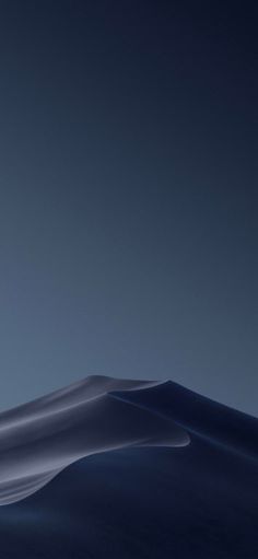 the moon is rising over some hills and sand dunes in the desert at night time