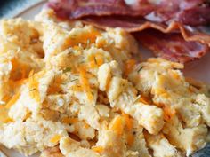 scrambled eggs, bacon and cheese on a plate