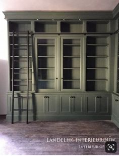 an empty room with green bookcases and shelves