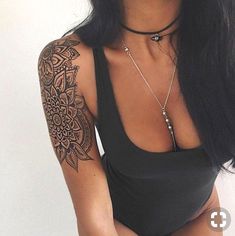 a woman with long black hair and tattoos on her arm