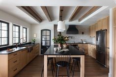 a large kitchen with wooden cabinets and black counter tops, along with an island in the middle