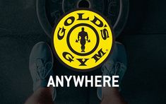 a person standing in front of a yellow and black gym sign with the words gold's gym on it