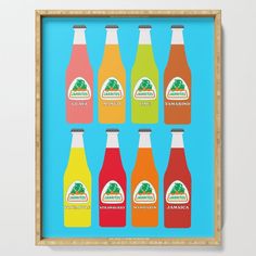 six bottles of orange, pink and green juice on a blue background framed in a wooden frame