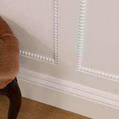 a brown chair sitting next to a white wall