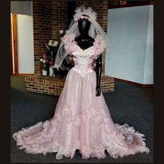 a mannequin wearing a pink wedding dress and veil