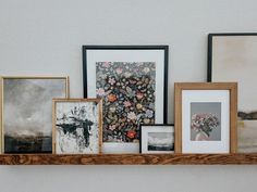 there are many framed pictures on the shelf