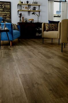 a living room with grey wood floors and furniture