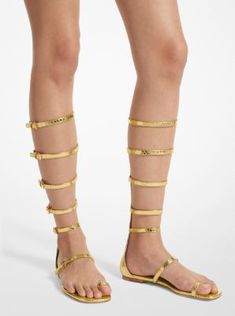 Our Italian-made Juliette sandals will lend a cool, bohemian edge to any ensemble. Styled with leggy silhouettes on the Spring/Summer 2024 runway, this metallic python-embossed leather pair features slender, leg-flattering straps and delicate gold-tone buckles for a polished finish. Balance the mid-calf design with the season’s flirty baby doll tank dress. Luxury Ankle Wrap Sandals For Spring, 2024 Runway, Leather Gladiator Sandals, Michael Kors Collection, Gold Sandals, Spring Summer 2024, Greek Mythology, Summer 2024, Gladiator Sandals