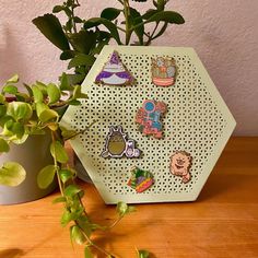 a wooden table topped with green plants and lots of pin's on top of it