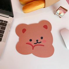 a laptop computer sitting on top of a desk next to a teddy bear sticker