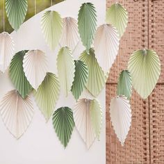 green and white paper leaves hanging on a wall