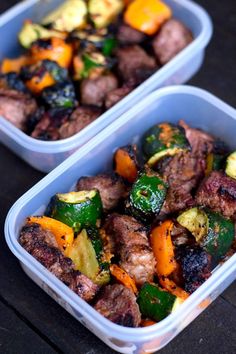 two plastic containers filled with meat and veggies on top of a wooden table