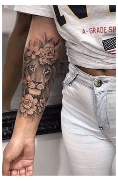 a woman's arm with a lion and flowers tattoo on her left arm, next to a mirror