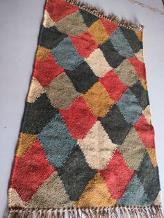 a multicolored patchwork rug with fringes on the bottom and one side