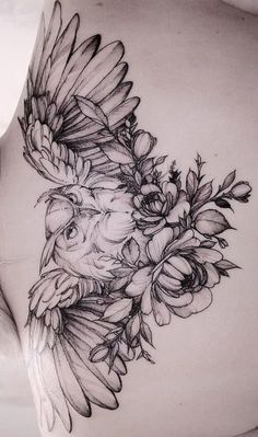 a woman's stomach with flowers and an owl tattoo on her side ribcage