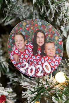 an ornament hanging from a christmas tree with the image of two children on it