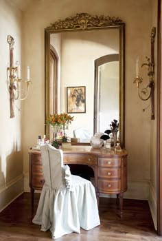 a dressing table with a chair and mirror