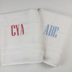 two white towels with red, blue and black letters on them that say crya and abe