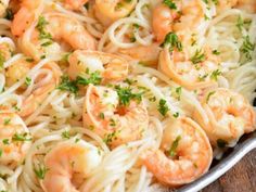 pasta with shrimp and parsley in a pan on a wooden table, ready to be eaten