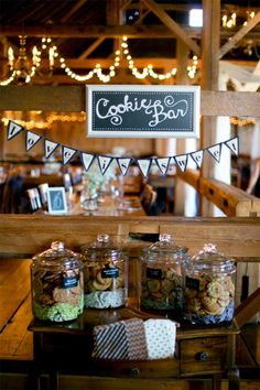 an image of some food in jars on a table with bunting and lights behind it