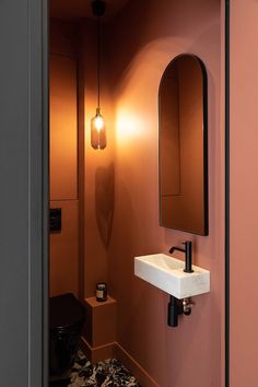 a bathroom with a sink, mirror and light fixture in it's center area