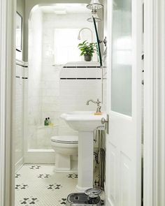 a white bathroom with black and white tile flooring