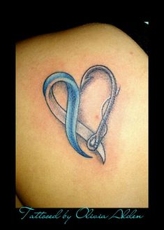 the back of a woman's shoulder with a blue ribbon and scissors in it