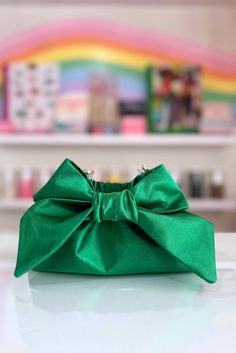 The Mimi Bow Clutch in Kelly Green is super lightweight and large enough to hold all your essentials. Featuring a satin fabric, a statement bow, a magnetic closure, and a detachable gold shoulder strap chain, this bag is perfect for a brunch, or evening out on the town. Handmade in Charleston, South Carolina by Mimi's mom, Keiko! This listing is for one 5" x 9”x 3” clutch. Formal Clutch Bag With Bow, Formal Clutch With Bow Detail, Formal Clutch With Bow, Chic Evening Bag With Detachable Bow, Chic Party Bag With Ribbon Detail, Chic Party Bag With Ribbon, Chic Clutch Bag With Bow, Chic Evening Bags With Bow, Clutch Bag With Bow For Events