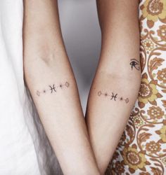 two people holding hands with tattoos on their arms, both have stars and an arrow